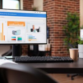 Computer with financial company data on charts in office. Empty business space with economy analytics following rate trend on monitor to make investment for organization development.